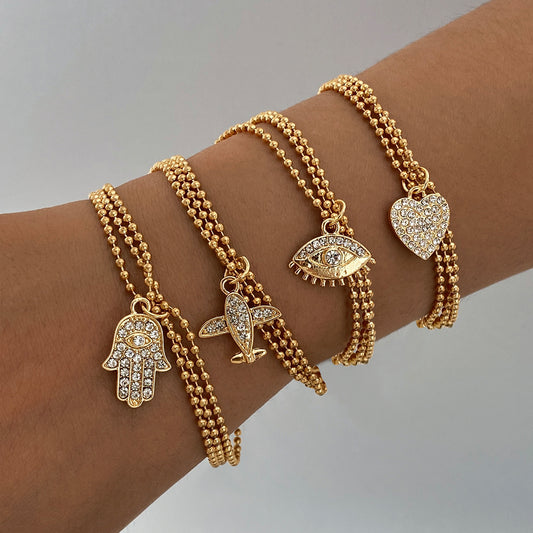 Conjunto de pulseras con dijes chapadas en oro – Colección Elegancia y Protección