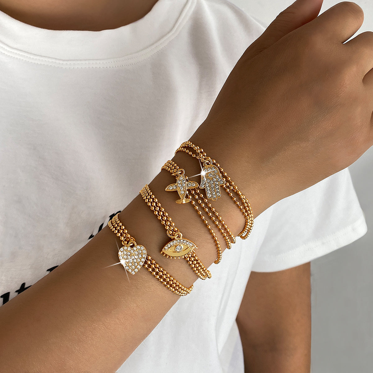 Conjunto de pulseras con dijes chapadas en oro – Colección Elegancia y Protección